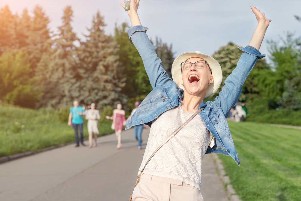 Happy Young Caucasian Bald Woman In Hat And Casual Clothes