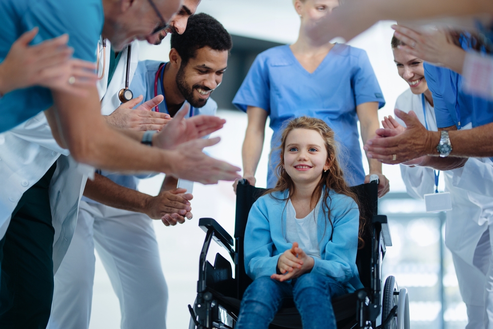 Medical Staff Clapping To Little Girl Patient Who Recovered From
