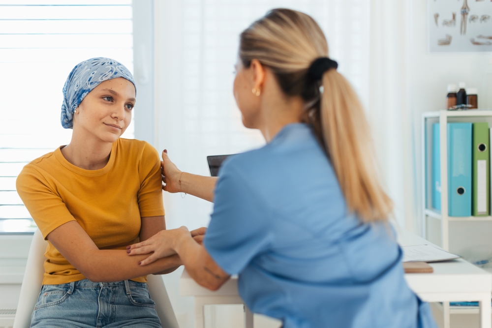 Teenage Oncology Patient Talking With Doctor Oncologist Treating Teen Girl
