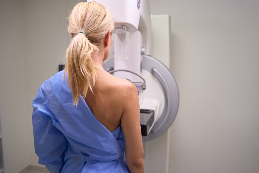 Adult Caucasian Woman Undergoing Screening Mammogram In Clinic
