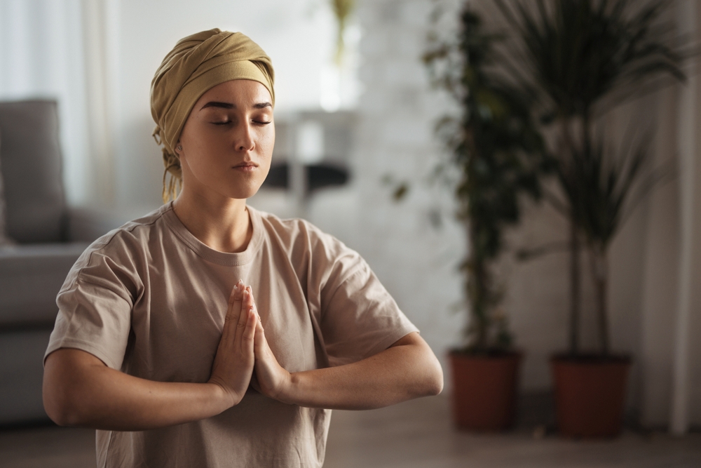 Young Woman With Cancer Taking Yoga And Meditating In Her