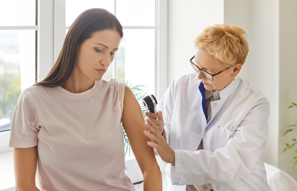Dermatologist Doctor Looking Very Closely At Woman Arm Skin With