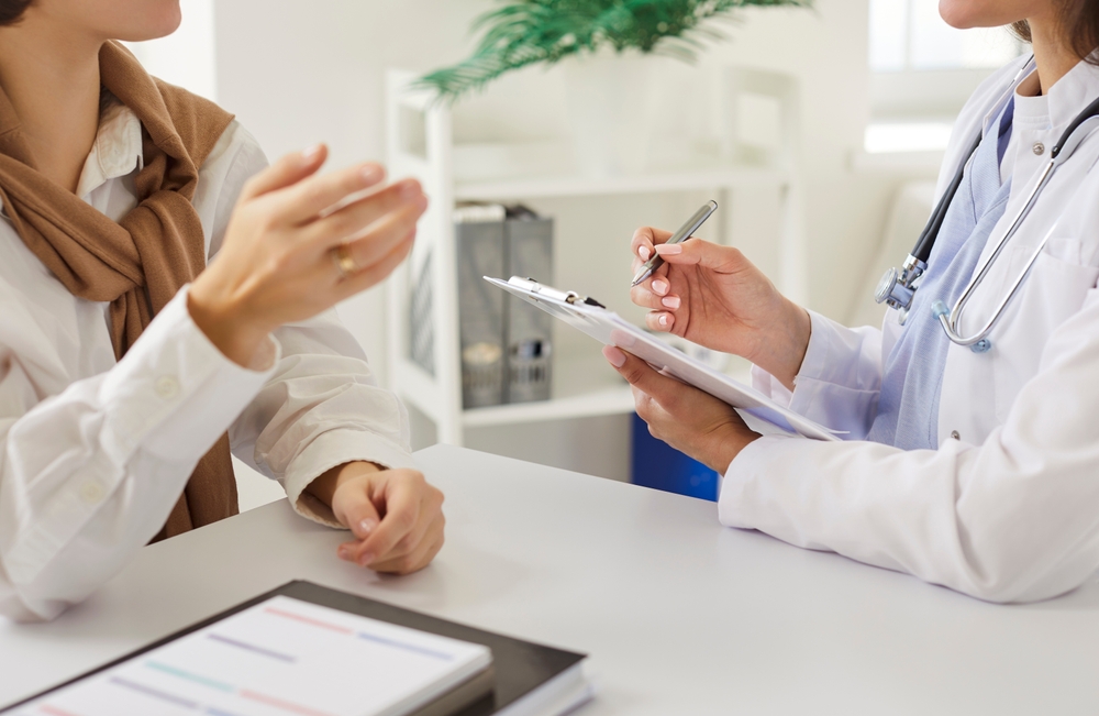 Cropped View Of Female Doctor Attentively Listening To Woman Patient