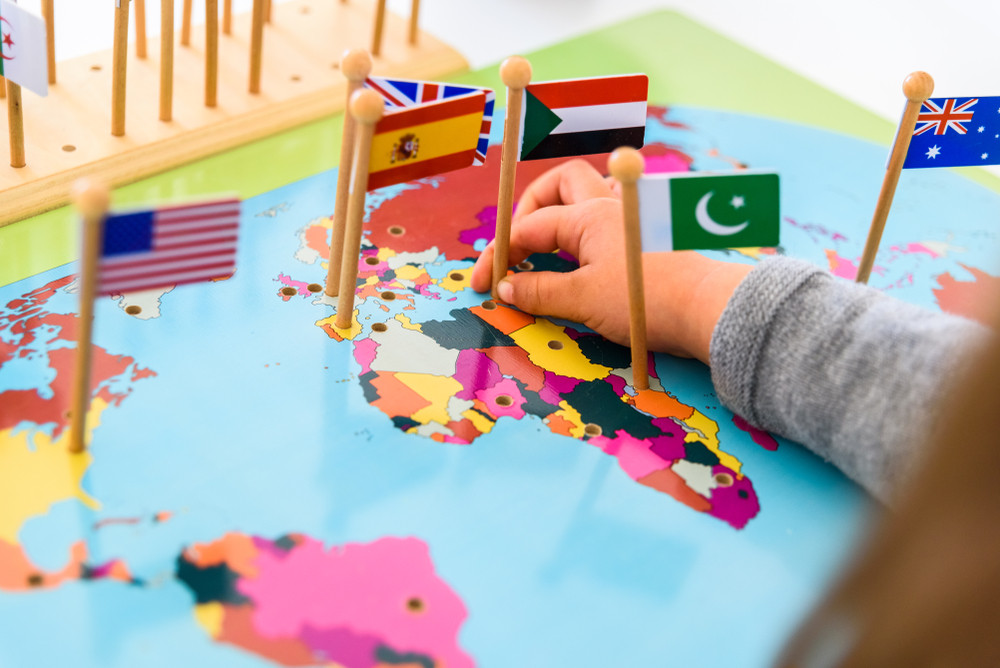 Girl Placing Flags Of Europe And Spain A Map