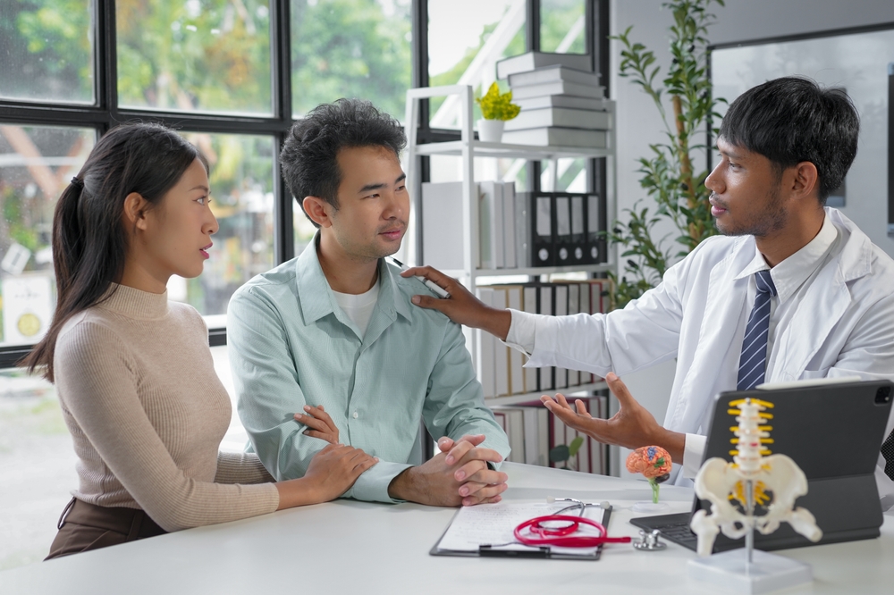 Doctor,Is,Comforting,A,Sad,Couple,During,A,Medical,Consultation Doctor Is Comforting A Sad Couple During A Medical Consultation