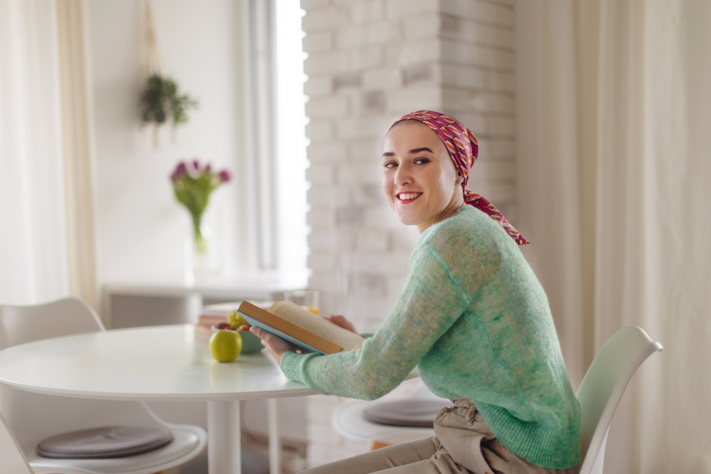 Young Woman With Cancer Reading Book Cancer Awareness Concept.