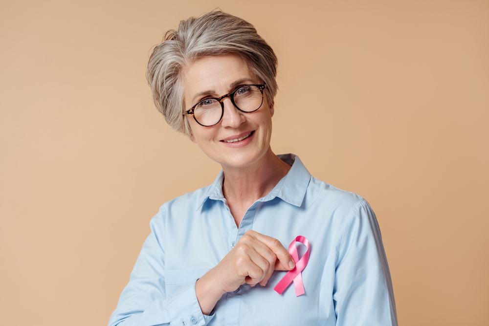 Portrait Of Smiling Confident Senior Woman Holding Pink Ribbon
