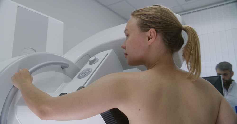 Adult Woman Stands Topless Undergoing Mammography Scanning Checkup In Clinic