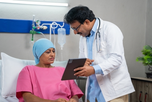 Indian Doctor Explaining Health Report From Digital Tablet To Admitted