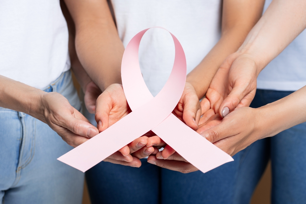 Diverse People Holding Pink Ribbon Showing Support For Breast Cancer