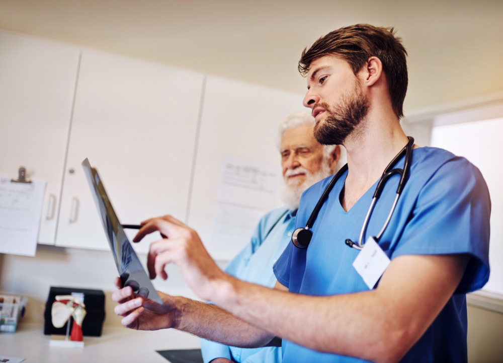 Clinic,,Discussion,And,Nurse,With,Xray,By,Man,For,Diagnosis, Clinic Discussion And Nurse With Xray By Man For Diagnosis