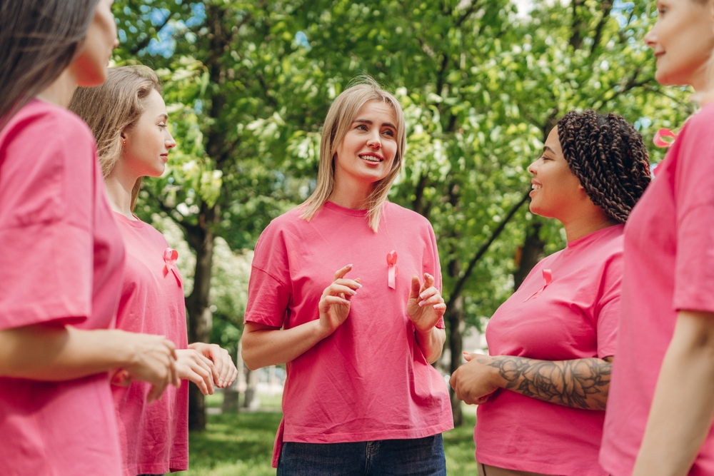 Volunteers Wearing Pink T Shirts With Pink Ribbons Are Talking