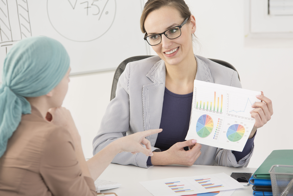 Smiling Doctor Holding A Piece Of Paper With Cancer Statistics