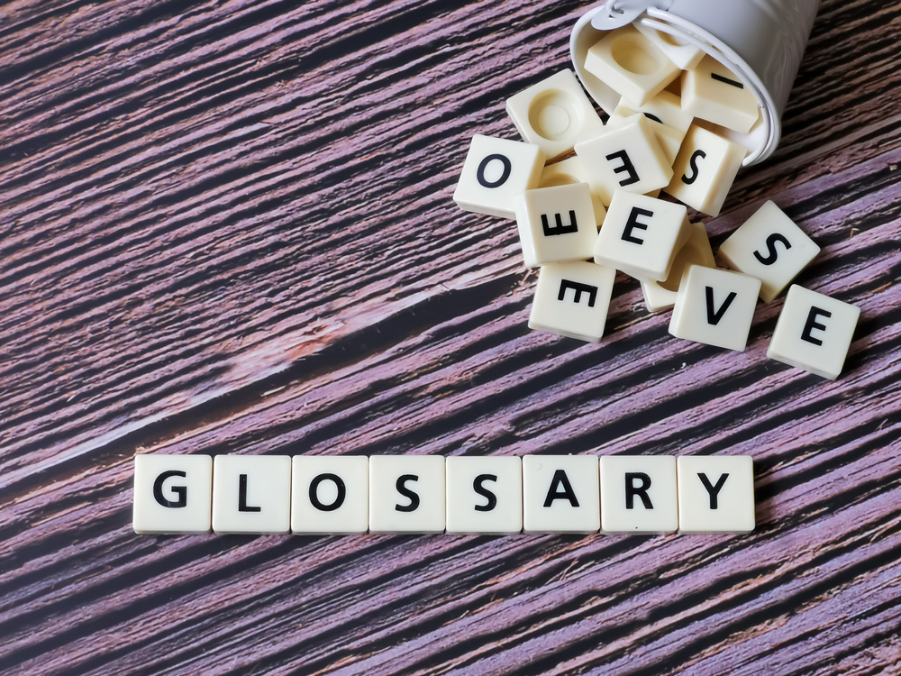 Glossary Word Made From Square Letter Tiles Wooden Background.