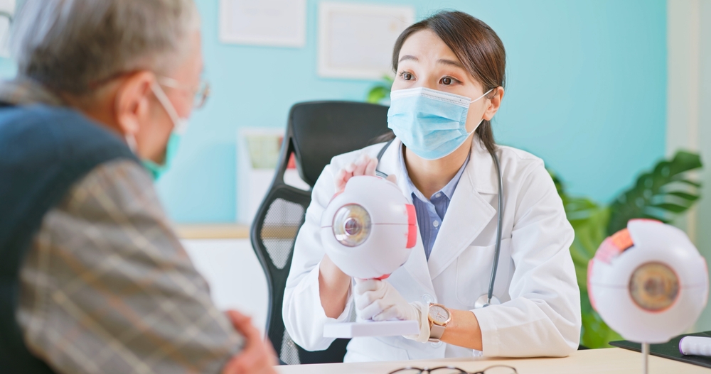 Asian Female Doctor Wearing Face Mask Is Showing Eyeball Model