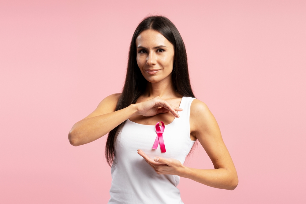 Smiling Latin Woman Wearing Shirt Showing Pink Ribbon Attached